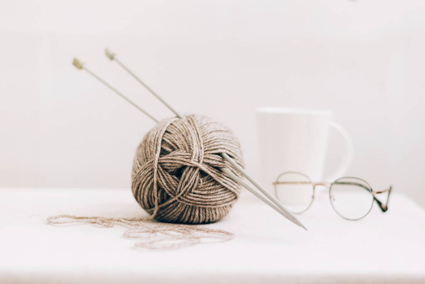 I fili per lavorare a maglia, da lana ecologica naturale, primo piano su uno sfondo leggero. Hobby casa cucito - Foto, immagini