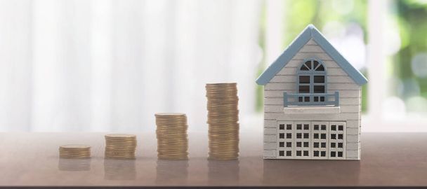 Modelo de miniatura independiente de la casa de la maqueta y monedas. concepto de inversión inmobiliaria inmobiliaria - Foto, imagen
