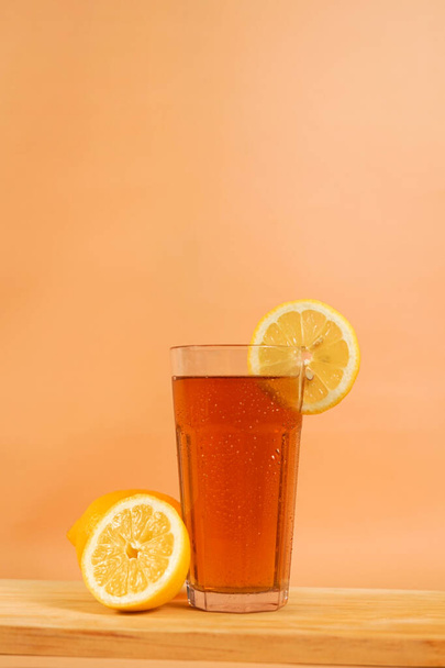 un vaso de té fotografiado para el espacio de copia de fondo. un juego de estudio de la bebida decorado con naranja en rodajas para publicidad y póster. - Foto, imagen