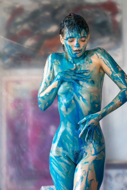 young beautiful woman posing nude, painted with blue paint - Foto, Imagen