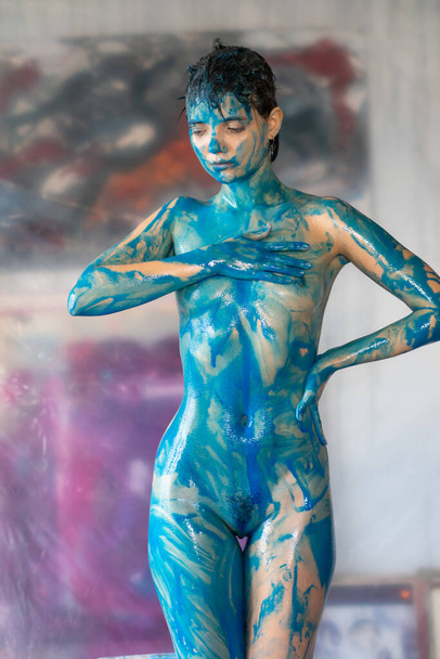 junge schöne Frau posiert nackt, bemalt mit blauer Farbe - Foto, Bild