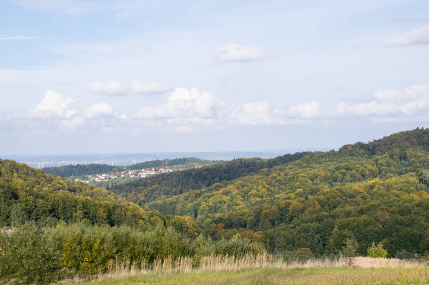 Landscape overlooking high mountains and glades. In the distance a strip of trees and buildings. - Fotografie, Obrázek