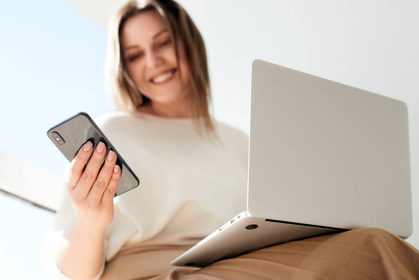 Cheerful freelancer browsing smartphone during work - Фото, зображення