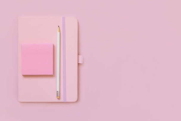 ピンクのノート、鉛筆、ライトピンクの上のビューに紙。教科書のモックアップ、プランナーの場所の足のテキストでカバー。教育、ビジネス、組織の概念 - 写真・画像