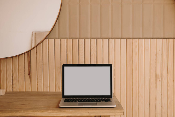 Κενό φορητό υπολογιστή οθόνης σε ξύλινο τραπέζι. Χώρος εργασίας γραφείου στο σπίτι. Αντιγράψτε χώρο mockup blog, πρότυπο ιστοσελίδα. Blogger, έννοια της εξωτερικής ανάθεσης εργασιών - Φωτογραφία, εικόνα