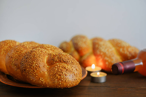 Şabat Şalom Challah ekmeği, Şabat şarabı ve ahşap masada mumlar. Boşluğu kopyala. - Fotoğraf, Görsel