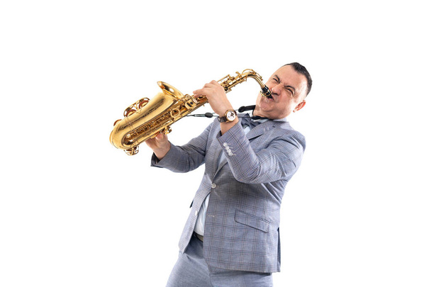 Expressive musician man in a suit plays on saxophone isolated on white background - Foto, immagini