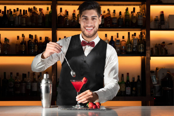 Joven barman sirviendo un cóctel en el club nocturno. - Foto, Imagen