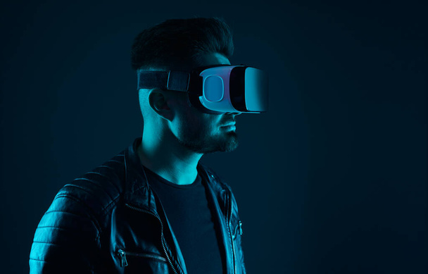 Man in glasses of virtual reality in dark room - Фото, изображение