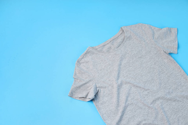 Blank gray t-shirt with space for print on blue background - 写真・画像