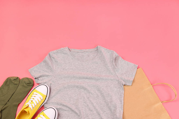 Leeres T-Shirt, Tasche, Turnschuhe und Socken auf rosa Hintergrund - Foto, Bild
