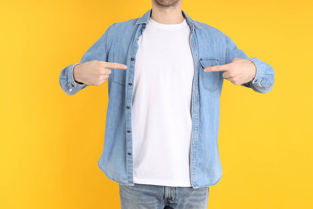 Man in blank t-shirt and in shirt on yellow background - Foto, imagen
