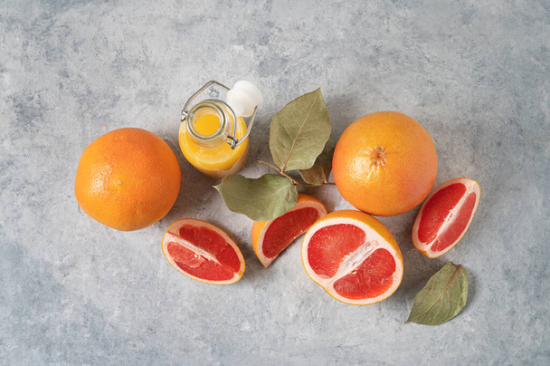 a lédús vörös grapefruit és gyümölcslé elrendezése egy kék hátterű üvegben. Koncepció egészséges és diétás ételek. Felülnézet és másolás. - Fotó, kép