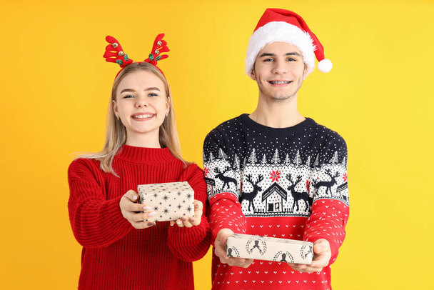 Cute para w Boże Narodzenie ubrania na żółtym tle - Zdjęcie, obraz