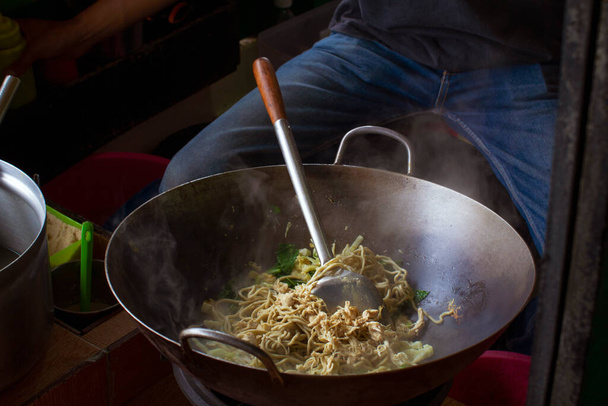 Смачна смажена локшина на жвавому вуличному продовольчому ринку
 - Фото, зображення