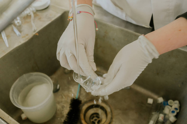 科学者は洗面台で実験器具を洗う - 写真・画像