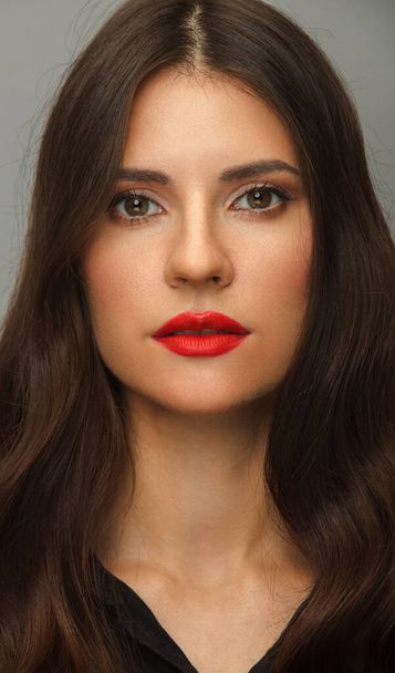 Vertical portrait of young brunette woman with red lips and long hair. - Foto, imagen