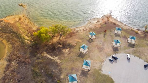 Top view λίμνη σκηνή και περίπτερο κατά μήκος ακτογραμμή με κοντινό πάρκινγκ στο Murrell Park, Τέξας, ΗΠΑ. Γραφικό κάμπινγκ, πεζοπορία, ψάρεμα, βαρκάδα αναψυχής στις βόρειες ακτές της λίμνης Grapevine - Φωτογραφία, εικόνα