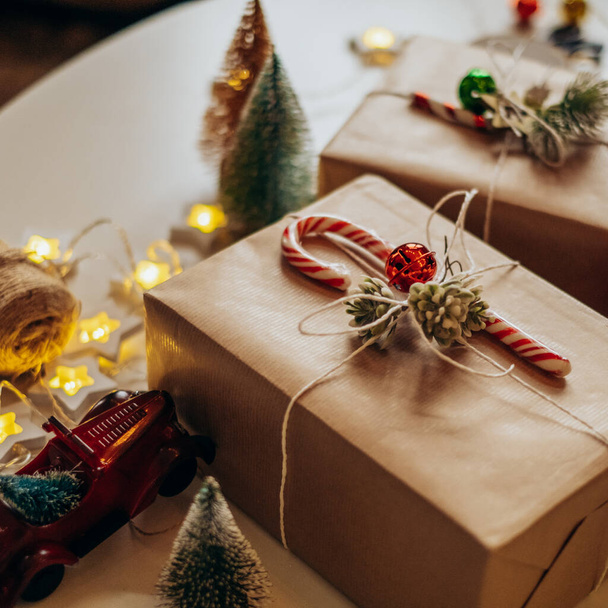 Regali di Natale si trovano sul tavolo in confezione festiva. Preparazione e decorazione della scatola - Foto, immagini