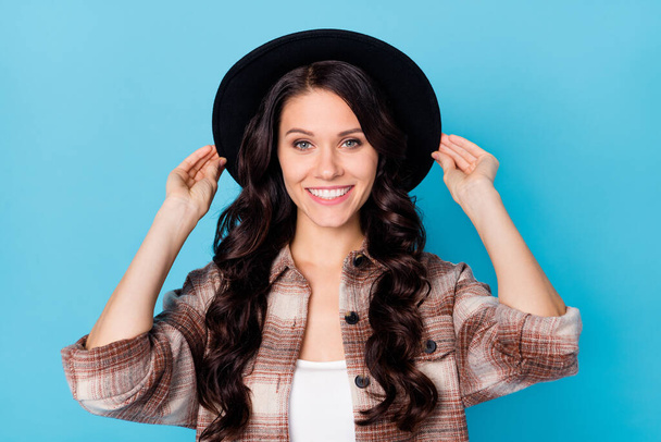 Photo of young beautiful charming pretty lovely cool smiling positive girl with black hat isolated on blue color background - Zdjęcie, obraz