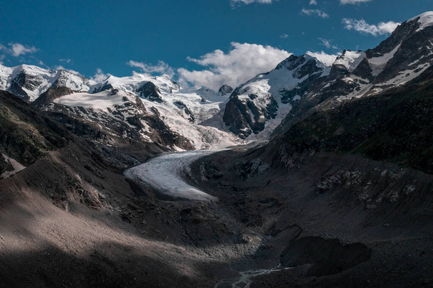 Morteratsch Glacier with snowy mountains in the Engadin in the Swiss Alps in summer with blue sky and sun - Fotó, kép