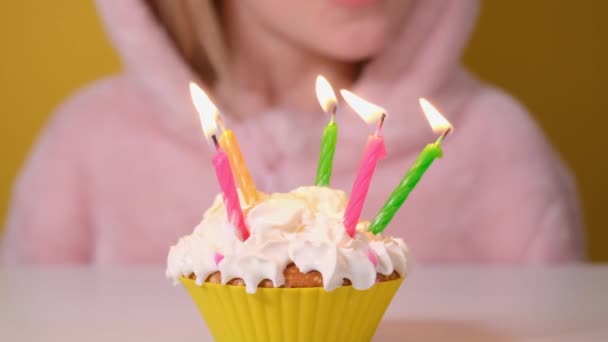 Šťastné dítě dívka v růžové kombinéze sfoukne pět svíček na narozeninovém dortu na párty. Zblízka dívčí tvář. Zpomalit film Happy birthday video banner - Záběry, video
