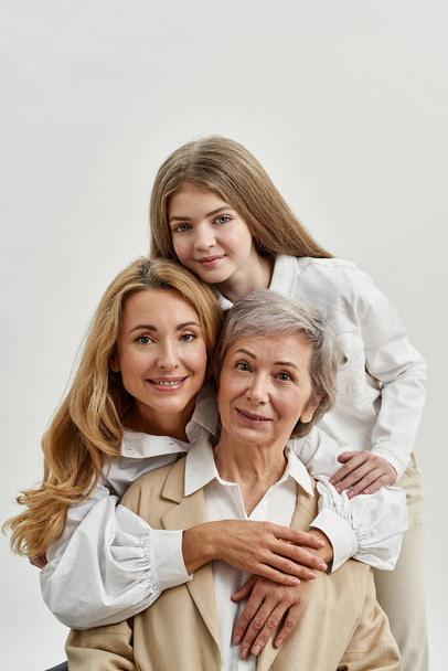 Pleased three female generations hug each other - Photo, image