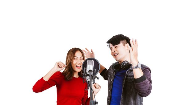 Csinos ázsiai női és férfi énekesek felvétel dalok segítségével stúdió mikrofon és pop pajzs a mikrofon szenvedéllyel zenei stúdió fehér háttér. Duett ülés. - Fotó, kép