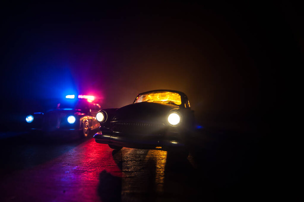 Coche de policía persiguiendo un coche por la noche con niebla de fondo. 911 Emergencia respuesta coche de policía exceso de velocidad a la escena del crimen. Enfoque selectivo - Foto, imagen