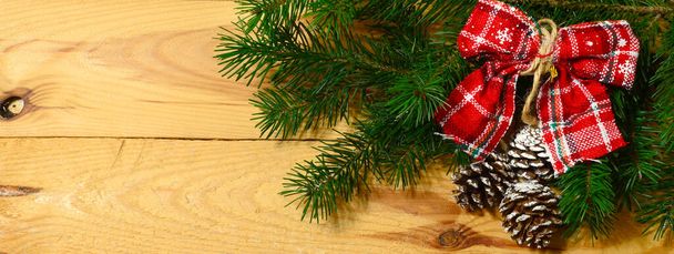 Christmas banner with fir tree branch, pine cones and decorations on wooden background - Fotografie, Obrázek