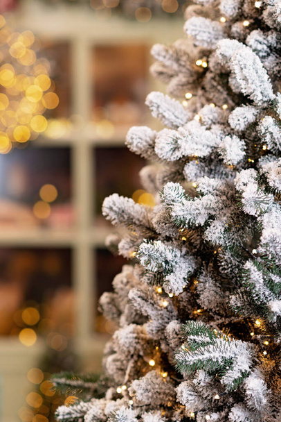 Karla kaplı ev yeni yıl için dekore edildi. Noel ağaçları, fenerler ve taze hamur işleriyle süslenmiş klasik kış avlusu. Yumuşak seçici odak. - Fotoğraf, Görsel