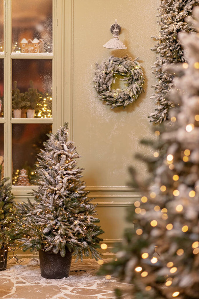 Lumen peittämä talo on sisustettu uutta vuotta varten. Vintage talvi piha, koristeltu uudenvuoden koristeet, joulukuuset, lyhdyt valot. Pehmeä valikoiva kohdentaminen. - Valokuva, kuva