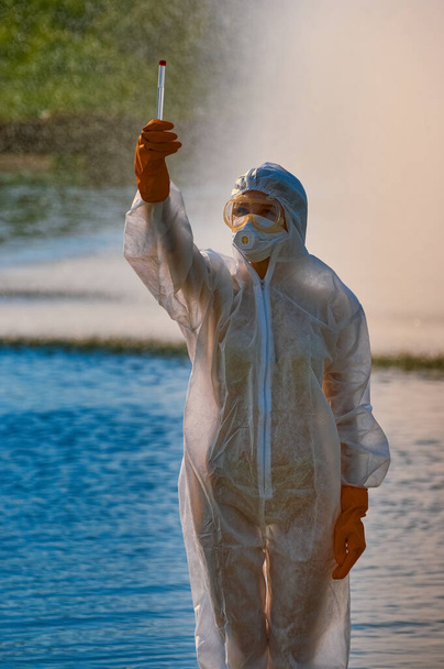 checking the water by a specialist in a protective suit and mask - Foto, Imagem