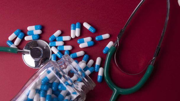 фонендоскоп и сине-белые таблетки - Фото, изображение