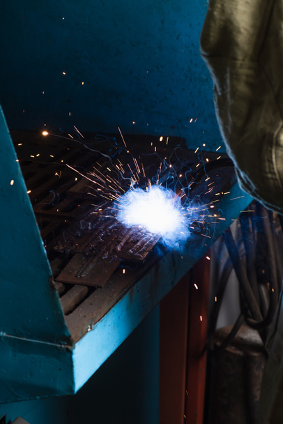 Cropped view of welder working with sparkling torch in factory  - Foto, Imagen