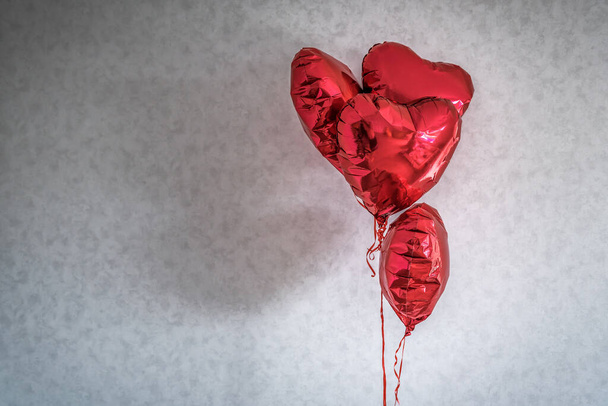 Egy csomó piros ünnepi szív alakú léggömb és fal háttér - Fotó, kép