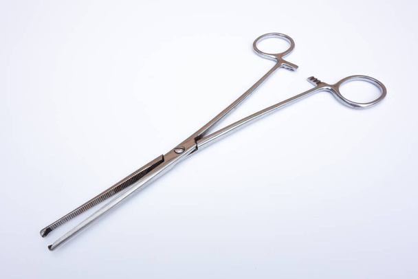 Pinzas de pinza médica para operaciones en aislado blanco. Instrumento quirúrgico sobre fondo blanco. - Foto, Imagen