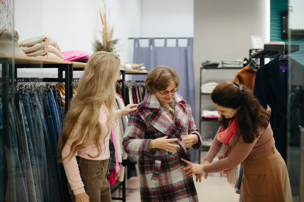 Літня жінка пробує одяг у роздягальні магазину одягу
 - Фото, зображення