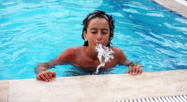 水を吐き若い 10 代の少年 - 写真・画像