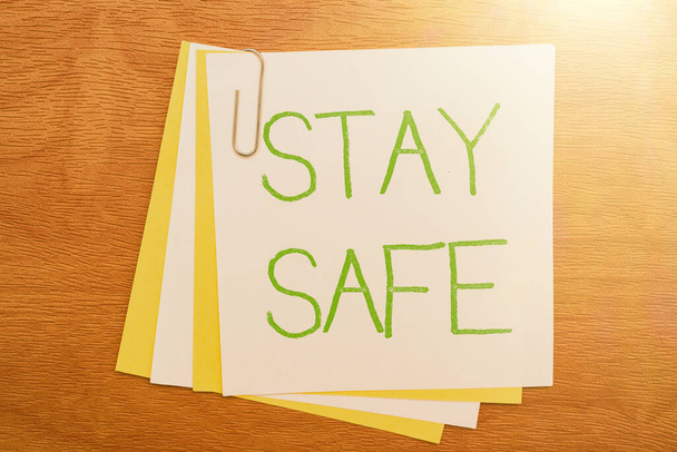 Podpis tekstowy przedstawiający Stay Safe. Podejście biznesowe zabezpieczone przed zagrożeniem niebezpieczeństwem, uszkodzeniem lub miejscem przechowywania przedmiotów Wielokrotna kolekcja materiałów biurowych Zdjęcie umieszczone nad stołem - Zdjęcie, obraz