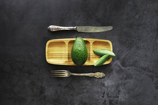 Avocado-Kochrezepte. Reife grüne Avocado auf einem Holzschneidebrett. - Foto, Bild
