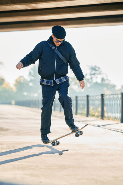 Skateboarder does ollie trick on street urban background - Foto, Imagem