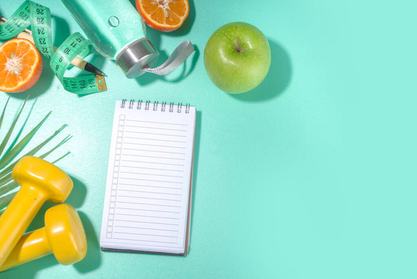 Spring, summer slimming season concept. Sport bottle with water, fitness dumbbells, beach lounger decor, measuring tape, notepad, apple, sliced orange on light blue white background. Flatlay copy space top view - Fotoğraf, Görsel
