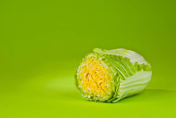 Peking cabbage on a green background. Cabbage close up. Copy space and place for text near greenery. - Photo, Image