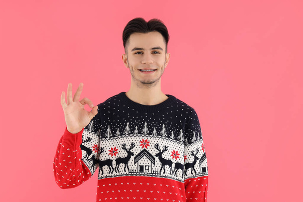 Vonzó srác karácsonyi pulóver rózsaszín háttér - Fotó, kép
