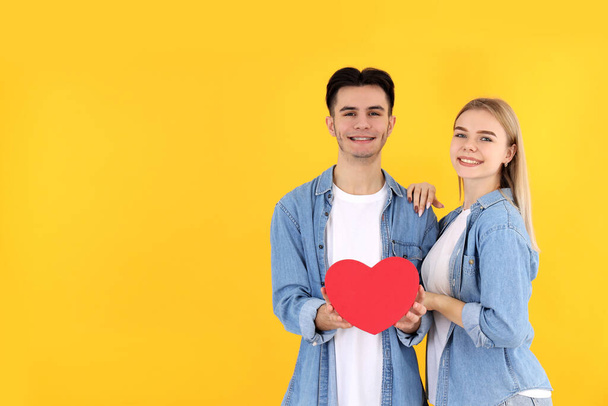 Cute couple with heart on yellow background - 写真・画像