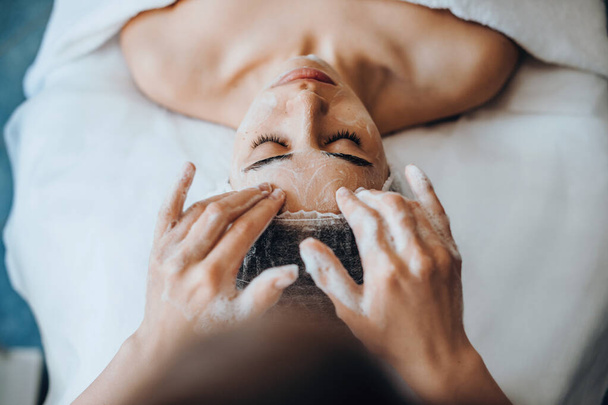 Retrato de primer plano de manos esteticistas aplicando espuma limpiadora facial. Dermatología, cosmetología. - Foto, Imagen