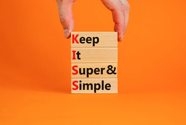 KISS keep it super and simple symbol. Concept words KISS keep it super and simple wooden blocks. Beautiful orange table, orange background. Business KISS keep it super and simple concept. Copy space. - Φωτογραφία, εικόνα