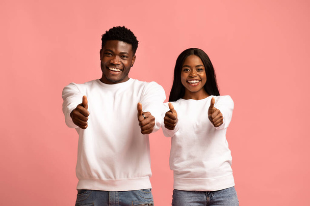 Счастливые африканские американец и женщина показывают большие пальцы вверх - Фото, изображение