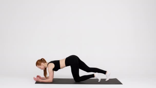 Αντοχή προπόνηση. Sporty νεαρή γυναίκα κάνει Plank Άσκηση Στο Ματ Στο Στούντιο - Πλάνα, βίντεο